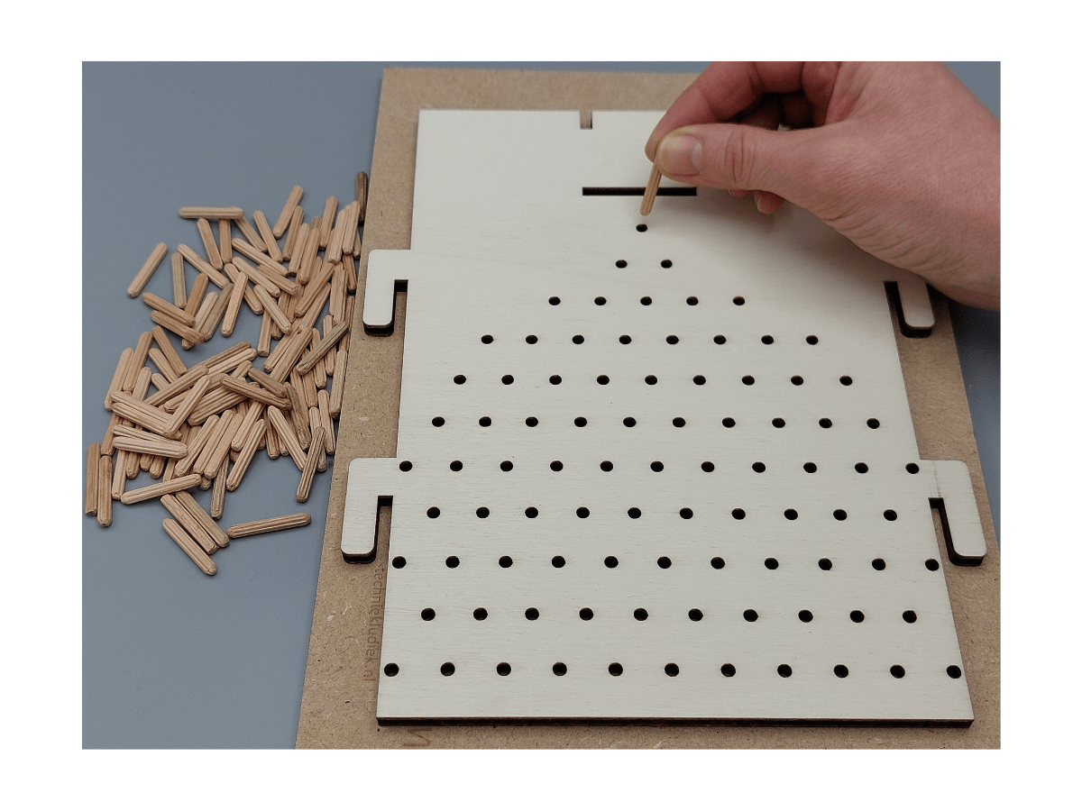 Kind monteert deuvels van het knutselpakket Kundige Knikkervanger