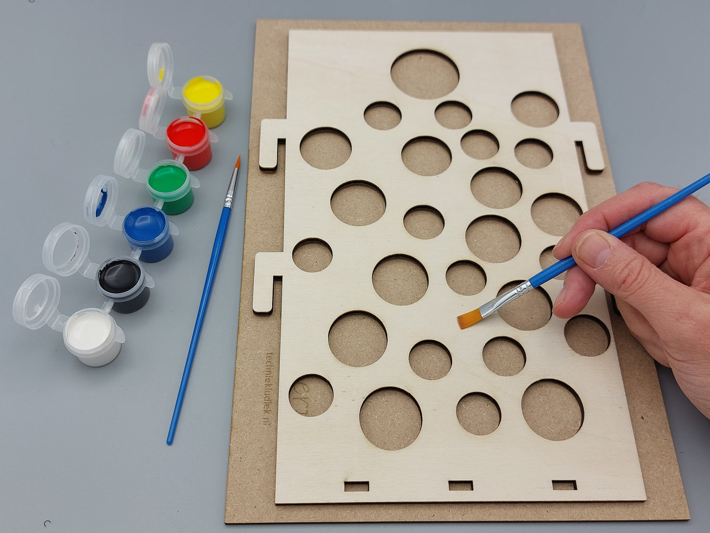 Het schilderen van de houten gatenbaan van Gatengekte; voor creatief knutselen (DIY) met kinderen tijdens een kinderfeestje.