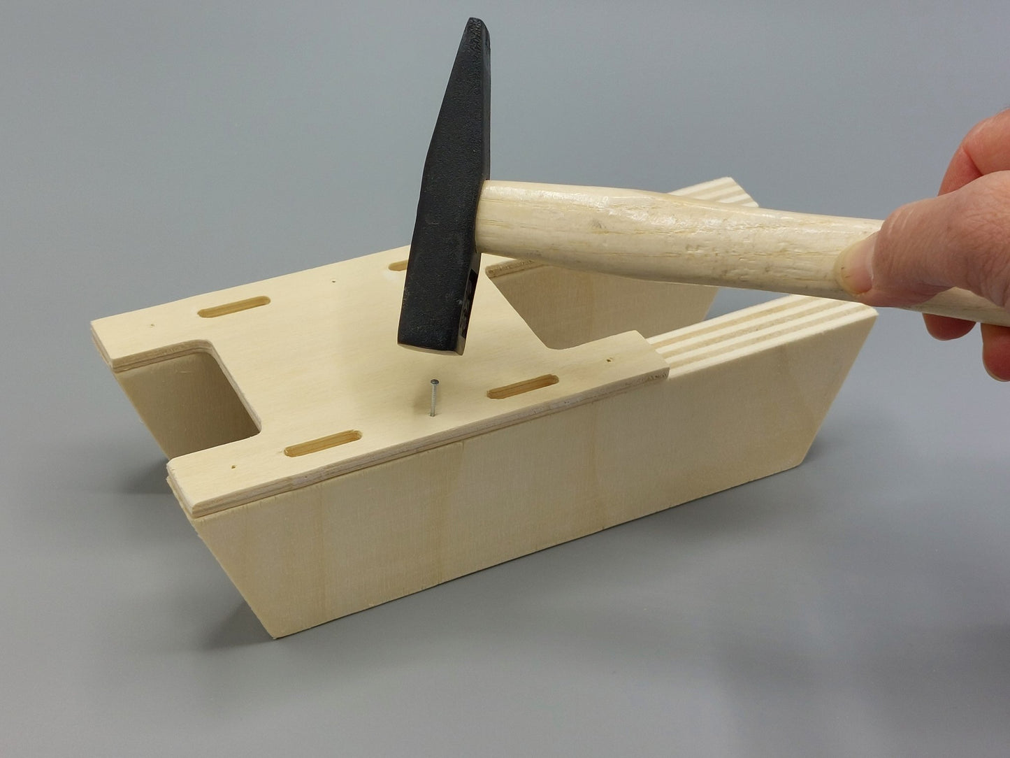 Knutselen voor kinderen met knutselpakket Badderende Boot – kind timmert houten onderdelen vast met een kleine hamer