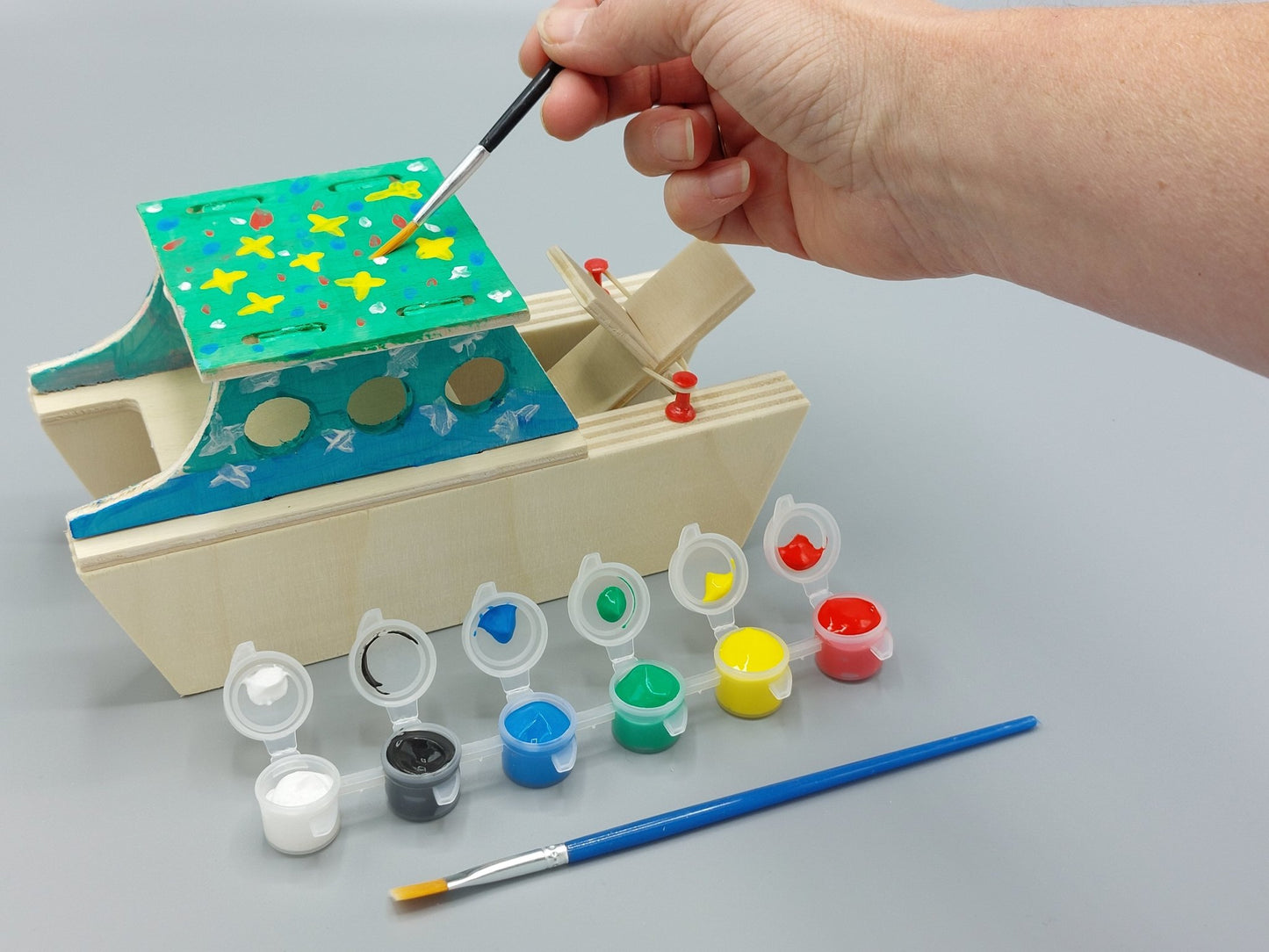 Knutselen voor kinderen met knutselpakket Badderende Boot – kind schildert zijn project in vrolijke, creatieve kleuren