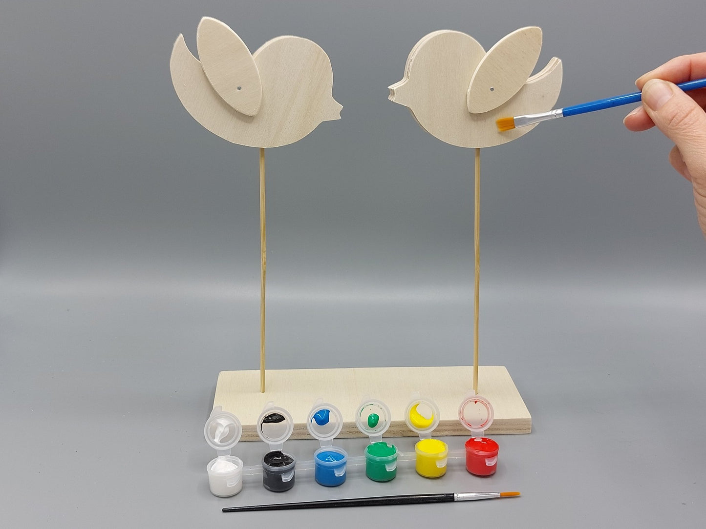 Knutselen voor kinderen met knutselpakket Vrolijke Vogels – kind schildert zijn project in vrolijke, creatieve kleuren
