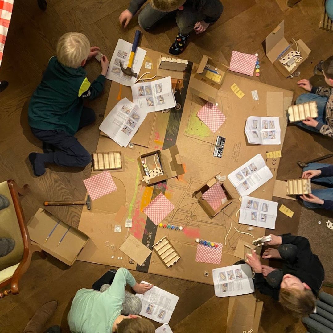 Kinderen knutselen samen tijdens een kinderfeestje thuis met houten bouwpakketten
