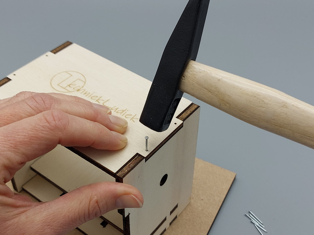 Timmeren met hamer bij montage van knutselpakket Slimme Sint