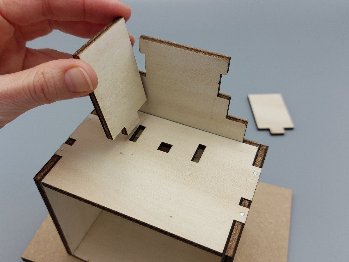 Montage van de schoorsteen van het houten knutselpakket Slimme Sint